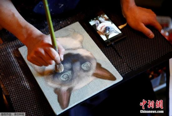当地时间2017年9月18日，日本东京，当地举办宠物葬礼博览会，一名画家为宠物画像。
