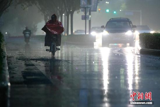 北京市民在雨中前行。 <a target='_blank' href='http://www.chinanews.com/'>中新社</a>记者 刘关关 摄