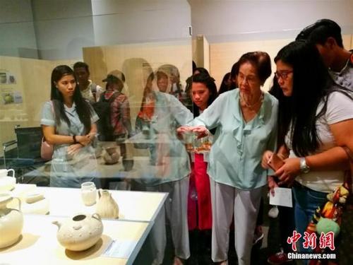 中国侨网9月30日是“菲律宾发现的宋元福建陶瓷展”的最后一天，菲律宾一所高中的数十位师生前往马尼拉阿亚拉博物馆参观。图为庄良有女士（右二）在讲解千年前中国贸易陶瓷来到菲律宾的故事。中新社记者 关向东 摄
