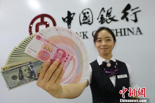 8月15日，山西太原，银行工作人员展示人民币、美元。<a target='_blank' href='http://www.chinanews.com/'>中新社</a>记者 张云 摄