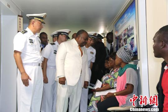 在中国海军和平方舟医院船，加蓬总统邦戈与等候就诊的加蓬民众亲切交谈。　刘洋 摄