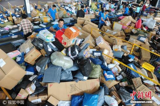 资料图：快递工作人员在分拣快递包裹。王彪 摄 图片来源：视觉中国
