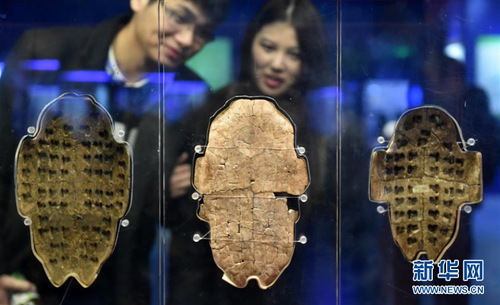 　市民在位于河南省安阳市的殷墟博物馆中参观刻有甲骨文的卜甲（11月25日摄）。  　　一片甲骨惊天下。100多年前的世纪之交，清代学者王懿荣在一种被称为“龙骨”的中草药上，发现了细小的刻画。这些神秘的符号经专家考证，被认定就是上古时期的文字——甲骨文，由此把中国有文字记载的历史提前了1000年。  　　100多年后的今天，甲骨文成功入选《世界记忆名录》，再次“惊”了天下。  　　新华社发（李嘉南 摄）