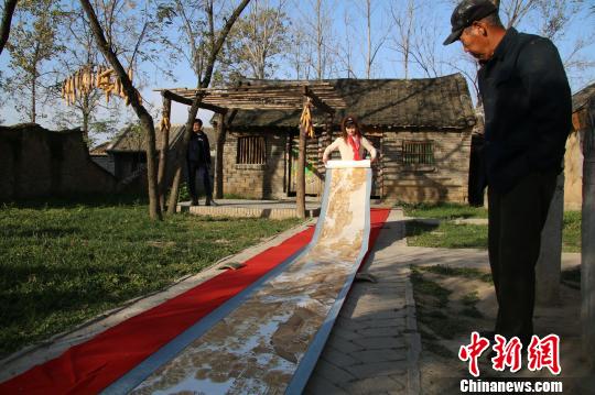11月27日，河南南阳烙画名家李跃平展示她的烙画《清明上河图》。　董飞　摄