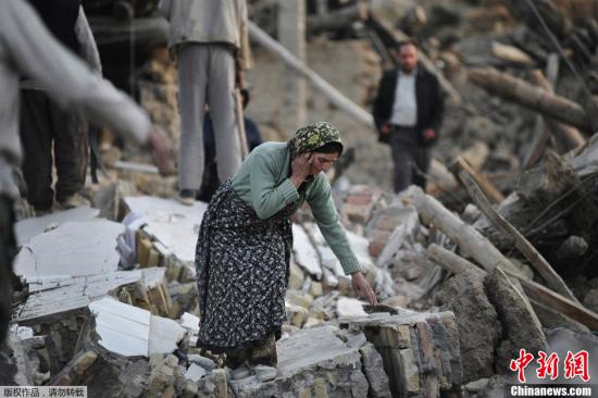 据外媒报道，伊朗卫生部长达斯特杰尔迪13日表示，截至目前，东阿塞拜疆省11日发生的地震已经造成306人死亡，3037人受伤。伊朗西北部东阿塞拜疆省11日连续发生两次6级以上地震，造成大量人员伤亡。图为当地时间8月12日，地震灾区一名妇女在废墟中。