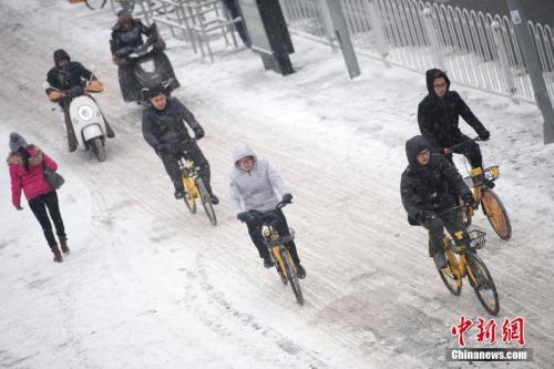 资料图：民众冒雪出行。中新社记者 韦亮 摄