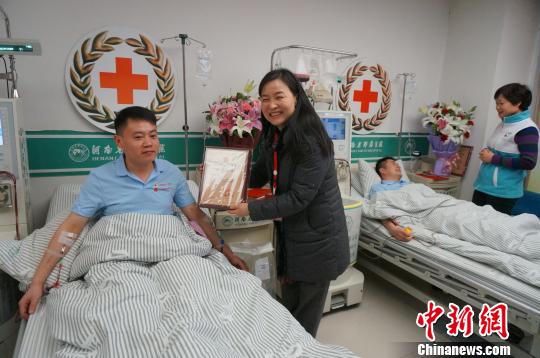 图为河南省红十字会领导向两名捐献志愿者颁发荣誉证书。　韩章云 摄