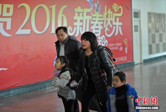 资料图：山西太原火车站，一对夫妻领着他们的两个孩子匆忙赶车。中新社记者 韦亮 摄