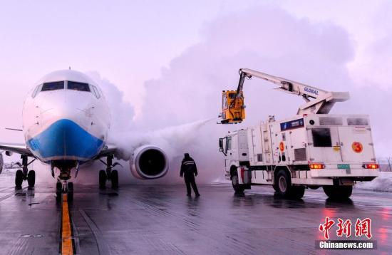 资料图：机务人员用器械给飞机除冰。贺晟 摄