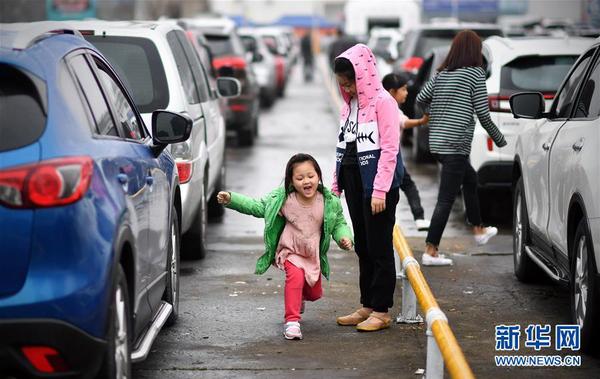 2月23日，小朋友在海口港的车辆等候区玩耍。