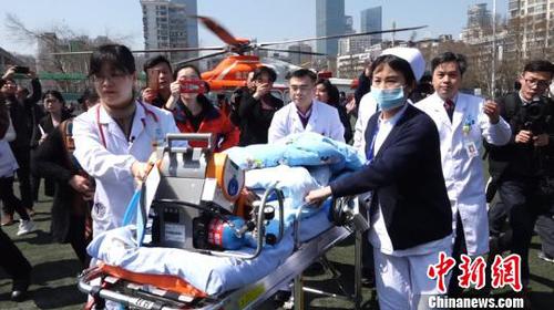 守候多时的武汉儿童医院医护人员，迅速将患儿送至救护车中。　郑子颜 摄