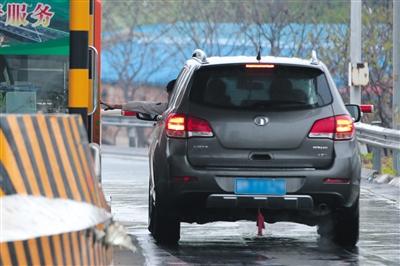 4月13日，土桥收费站，一位司机从车窗探出头取高速卡。摄影/新京报记者 朱骏 图片来源：新京报
