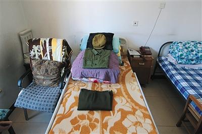 周智夫卧室的床铺上，他生前的衣物和被褥整整齐齐地叠放在一起。