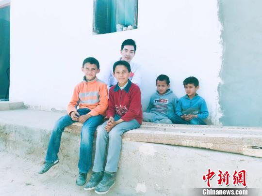 资料图：邓杰在突尼斯的乡村义诊，跟当地儿童合影留念。　受访者供图 摄
