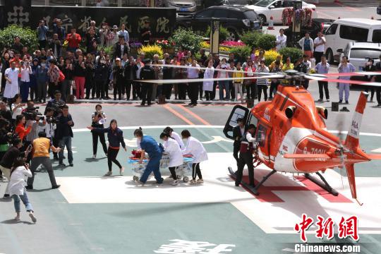 5月23日，辽宁省人民医院完成中国东北首例异地航空医疗转运任务。图为急救人员立即将患者抬上急救床。　朱明宇 摄