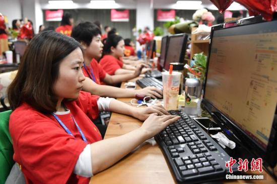 资料图：双十一网购节，广州一电商企业的员工们在电脑前解答消费者的购物疑问。<a target='_blank' href='http://www.chinanews.com/'>中新社</a>记者 陈骥旻 摄