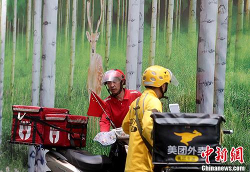 资料图：5月23日，北京西单街头的外卖骑手准备送餐。 <a target='_blank' href='http://www.chinanews.com/'>中新社</a>记者 张宇 摄