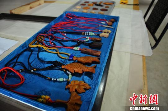 图为王吉涛雕刻的挂饰，其中一部分是他自己设计的形象。　郝学娟 摄