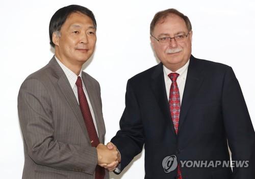 资料图片：6月26日，韩美在首尔举行旨在签订第10份防卫费分担协定的第四轮谈判。韩国外交部韩美防卫费分担谈判代表张元三(左)和美方谈判代表蒂莫西·贝茨握手合影。(图片来源：韩联社)