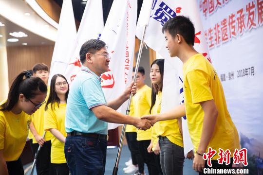 华侨大学校长助理张云波为2018年“中华文化之旅“6个研习营的学生代表授旗。伊凡 摄