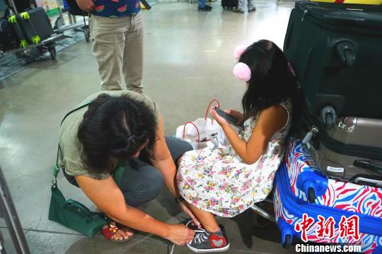 候机厅外不少滞留旅客将行李放在手推车上，靠着休息。　关向东 摄