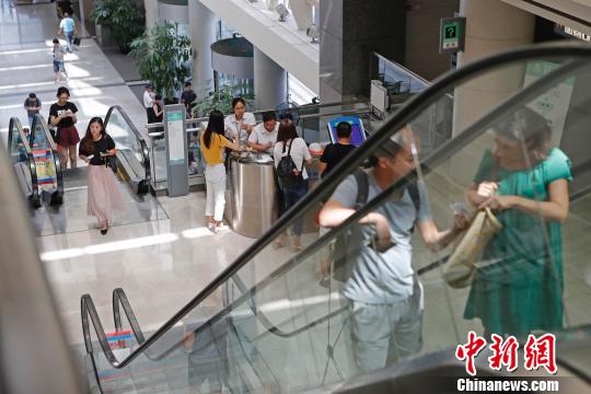 上海市公安局出入境管理局内，民众正在咨询和办理相关业务。　殷立勤 摄