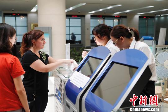 外籍人士正在上海市公安局出入境管理局内办理相关业务。　殷立勤 摄
