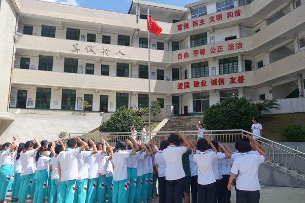 图2：开学第一天，岩山中学学生与岩山小学学生一起升国旗。