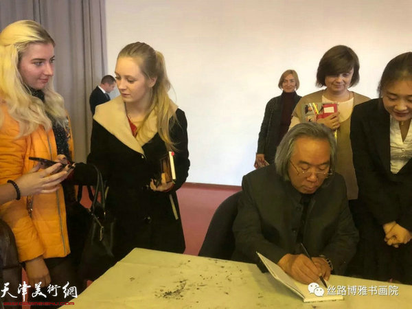 霍春阳在“中国画精神的内涵”讲座现场为喜爱中国书画的俄罗斯师生签名留念。