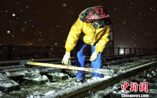 新疆铁路工作人员冒雪检查铁路线。　摆风亮 摄
