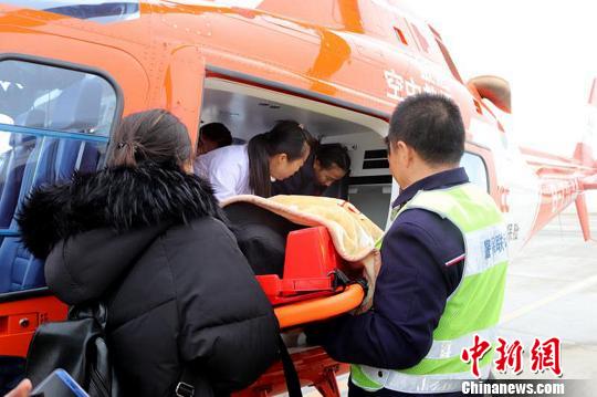 工作人员将病患转至直升机内。　李佩珊 摄