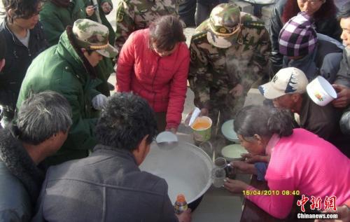 官兵在营地与灾民共同吃饭。武警玉树支队 赵飞 供图