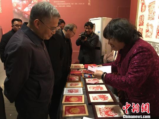 文化和旅游部党组成员、副部长项兆伦参观丰宁满族剪纸展位。　高红超 摄