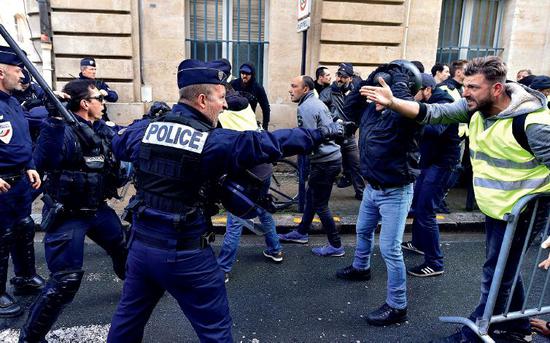 11月24日，法国巴黎街头“黄背心”与警方发生冲突。图/新华社