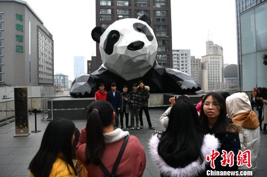 在大熊猫雕塑前合影的市民。　张浪 摄