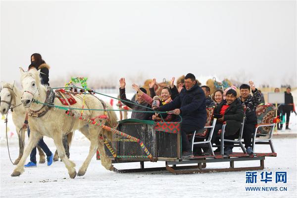 游客在南疆巴音郭楞蒙古自治州境内的博斯腾湖冰面上体验马拉爬犁（2月6日摄）。
