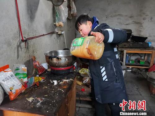 当天中午，刘奉智熟练地切白菜、刷锅、烧油，炖白菜汤，准备午饭。　郝学娟 摄