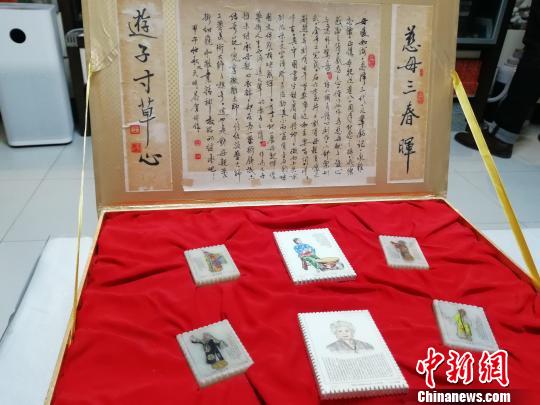 为纪念母亲张春秋，王天明做了一副微雕作品，在五块邮票样式的玉石上雕画了张春秋塑造的经典舞台形象，并刻上了她的京剧唱词。　孙婷婷 摄
