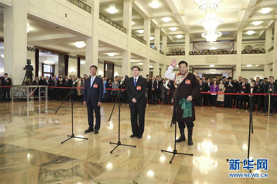 3月15日，十三届全国人大二次会议在北京人民大会堂举行闭幕会。这是全国人大代表符宣朝、张建东、白加扎西（从左至右）在“代表通道”接受采访。 新华社记者殷刚摄