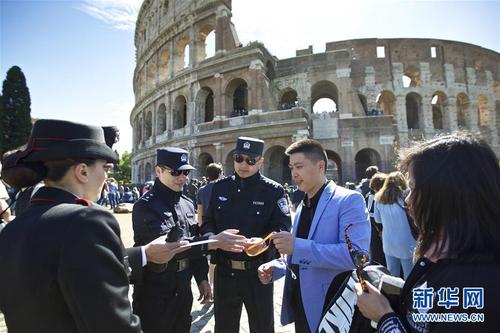 这是2016年5月2日，在意大利罗马斗兽场外，中方警员在核查一个中国旅游团的证件。当日，首次中意警务联合巡逻在意大利罗马启动。新华社记者金宇摄