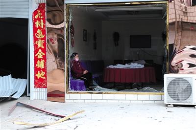 江苏响水王商村，一位村民坐在自家破损的窗户边。新京报记者 彭子洋 摄