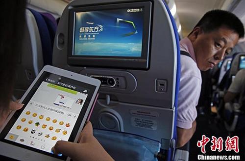 图为2014年7月23日，旅客在东航实际承运的航班上使用平板电脑(Pad)，进行空地互联微信聊天。 <a target='_blank' href='http://www.chinanews.com/'>中新社</a>记者 殷立勤 摄