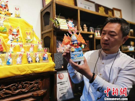 济南泥塑“兔子王”非遗传承人杨峰为参观者介绍“兔子王”的文化和历史。　赵晓 摄