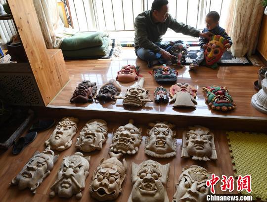 甘肃民间艺人马正德展示制作的傩面具。　杨艳敏 摄