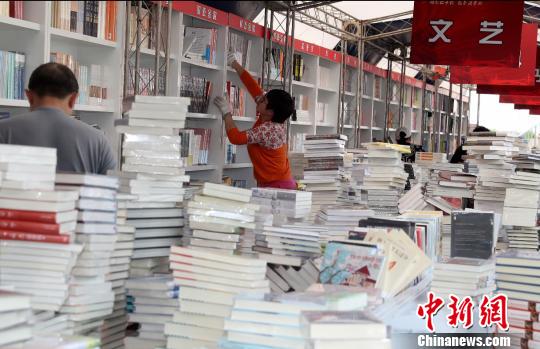 “北京书市”将于4月19日至29日在朝阳公园举办。图为工作人员正在布置展区内各个书架。(完) 张宇 摄