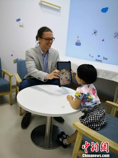 英国专家用AI猴与孩子开心互动。　陈静 摄
