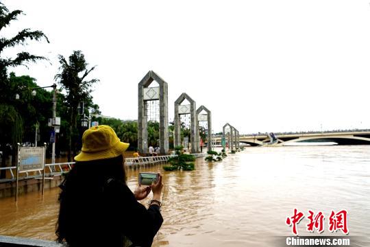 图为一民众在桂林解放桥滨江路拍摄洪水。　唐梦宪 摄