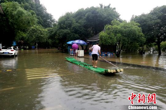 图为桂林穿山公园部分被淹，附近民众用竹笺出行。　唐梦宪 摄