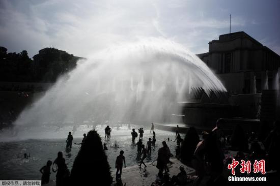 当地时间2019年6月28日，法国巴黎，法国遭遇连日极端高温天气袭击，众多巴黎市民和游客聚集在埃菲尔铁塔前的喷水池泡水降温。