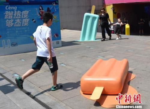资料图：图为重庆一广场现巨型雪糕模型，吸引小朋友眼球。　周毅 摄